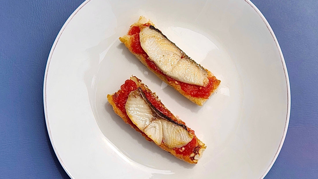 two pieces of toast with black cod and tomato paste