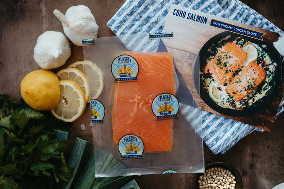 Wild coho salmon fillet in vacuum-sealed bag with recipe card and seasonings