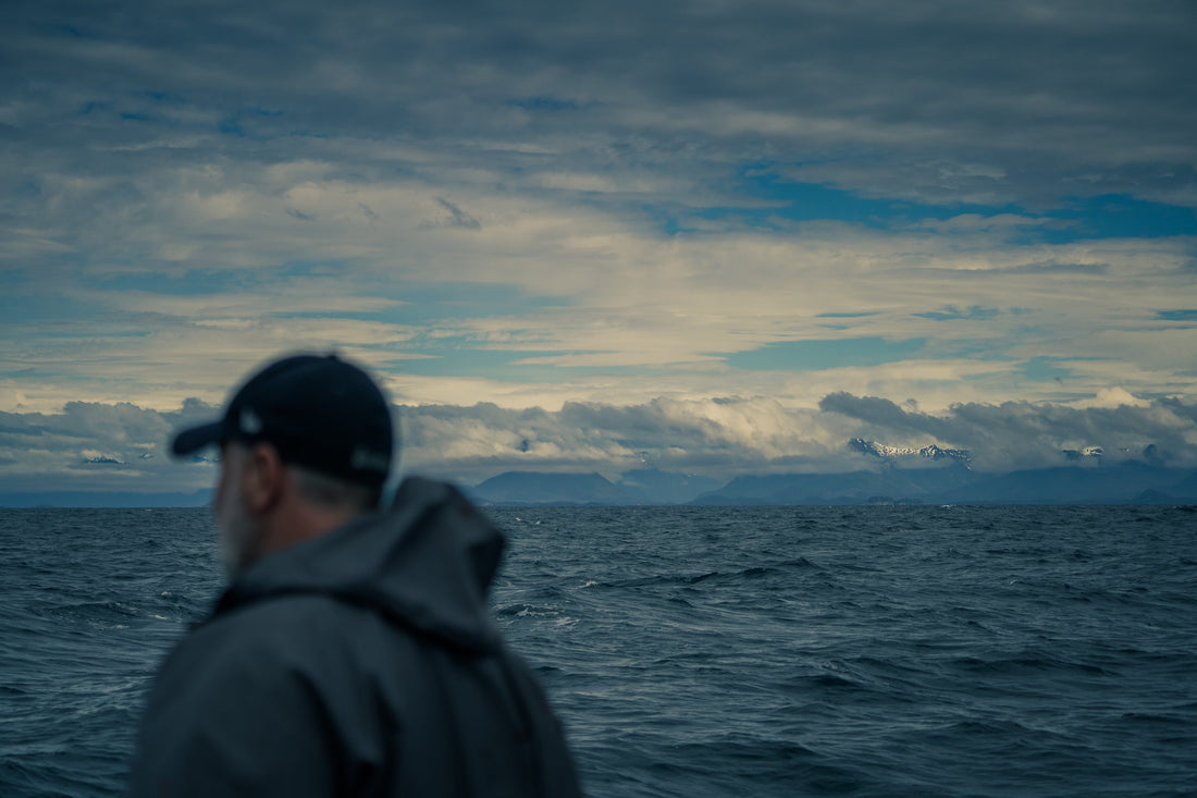 Fisherman on ocean looking at southeast Alaska mountain range