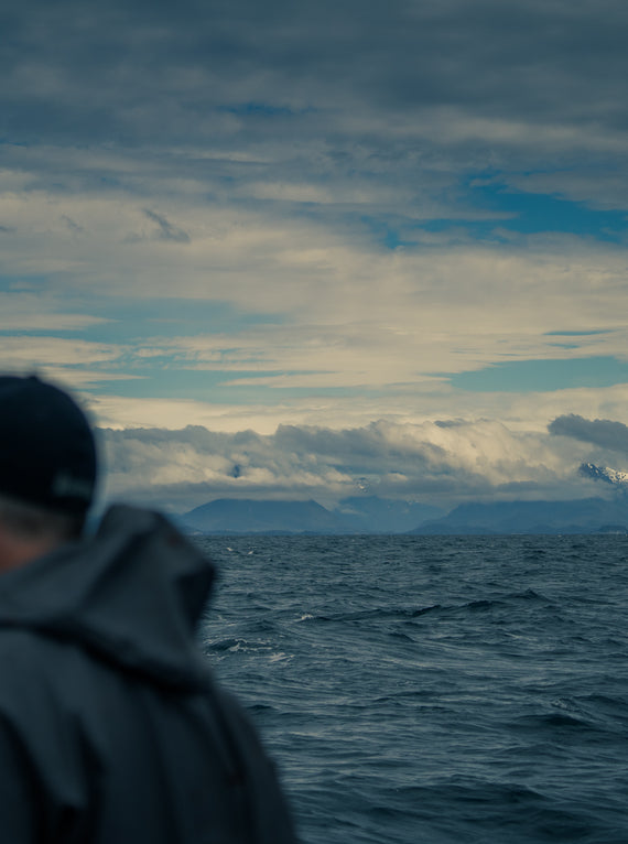 Fisherman on ocean looking at southeast Alaska mountain range