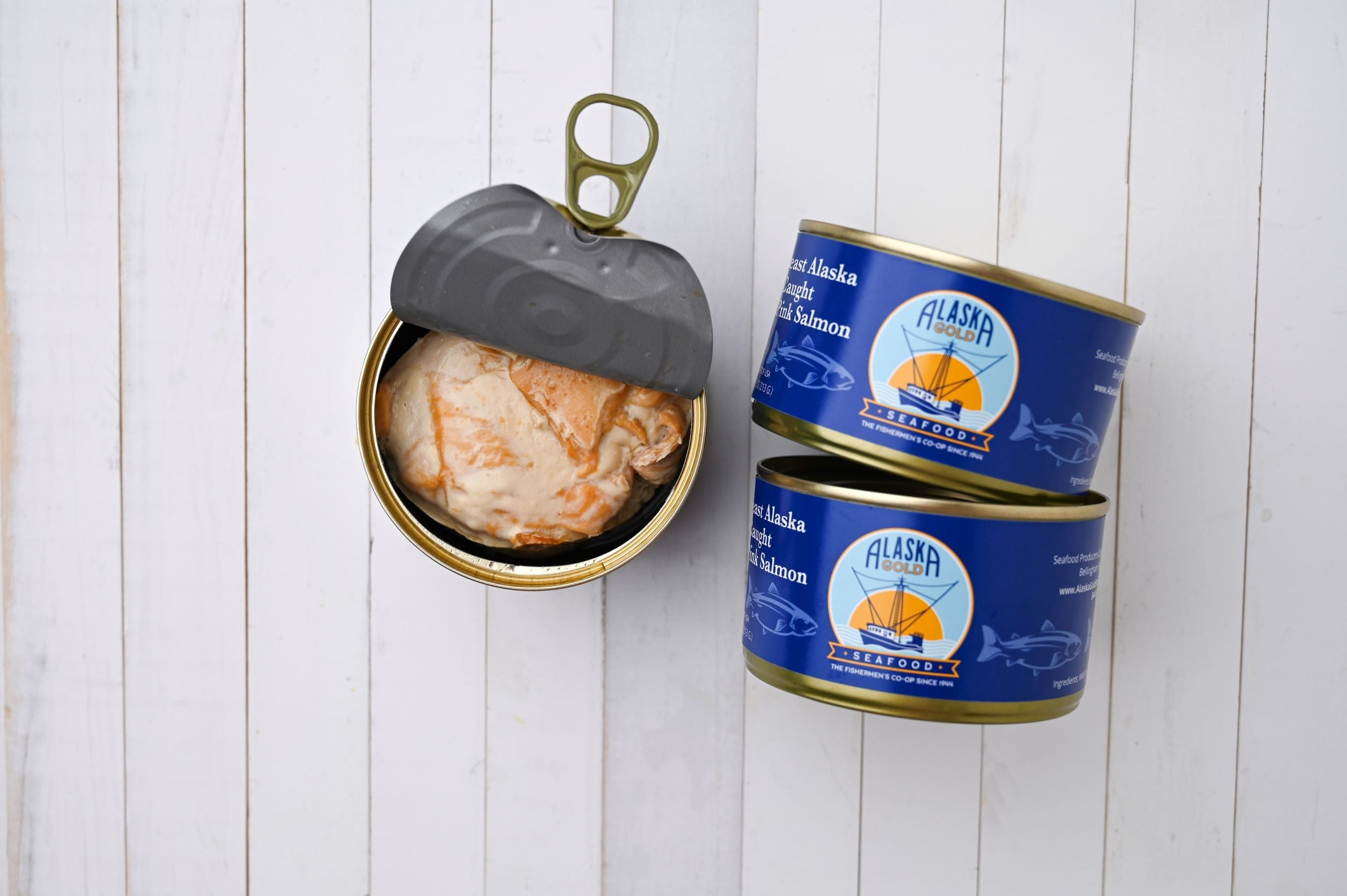Canned Salmon. 3 cans, one is open and 2 cans show the Alaska Gold Seafood label.
