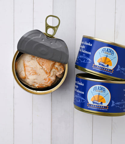 Canned Salmon. 3 cans, one is open and 2 cans show the Alaska Gold Seafood label.