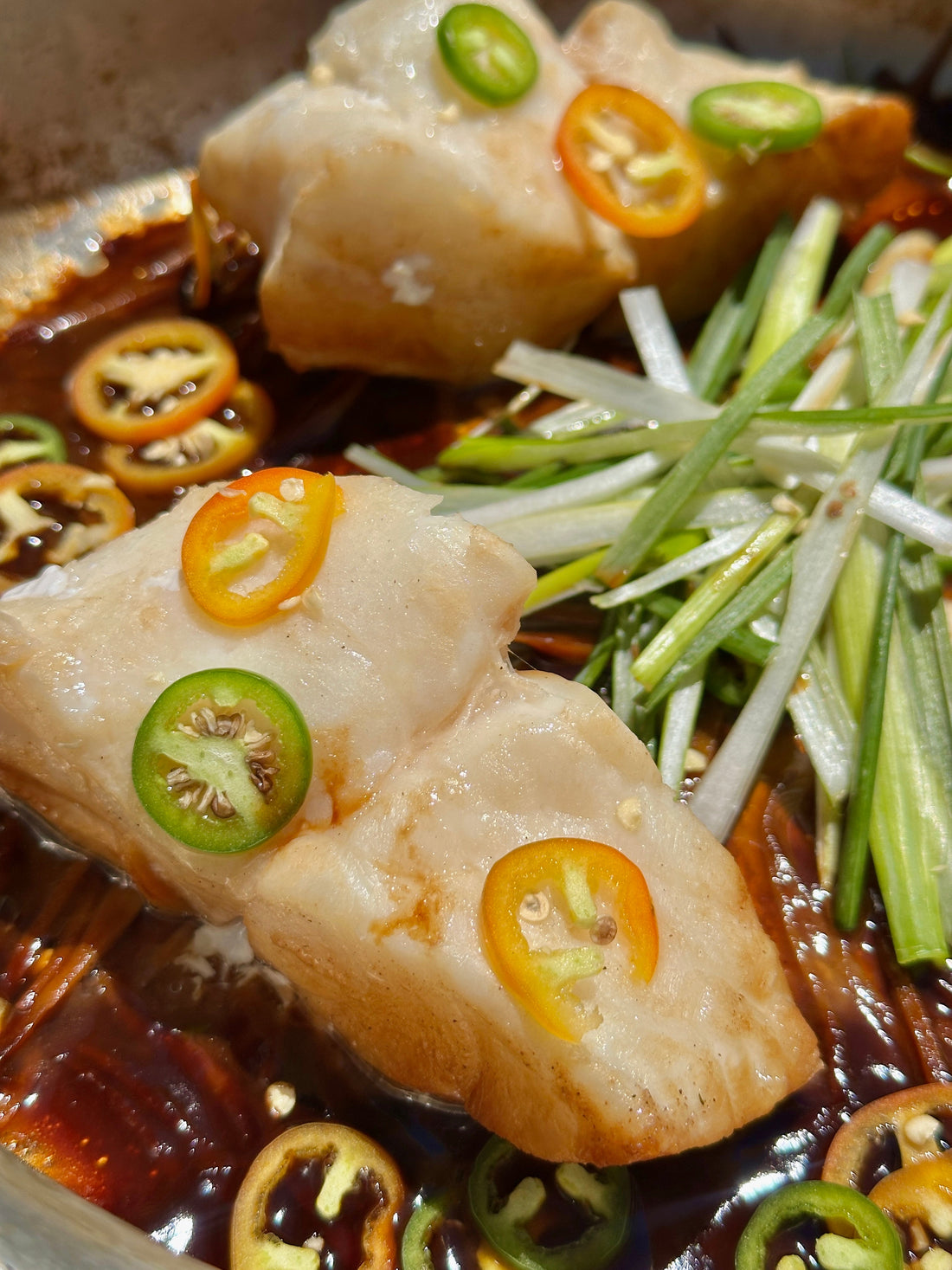 steamed yelloweye rockfish on a bed of chilis and vegetables