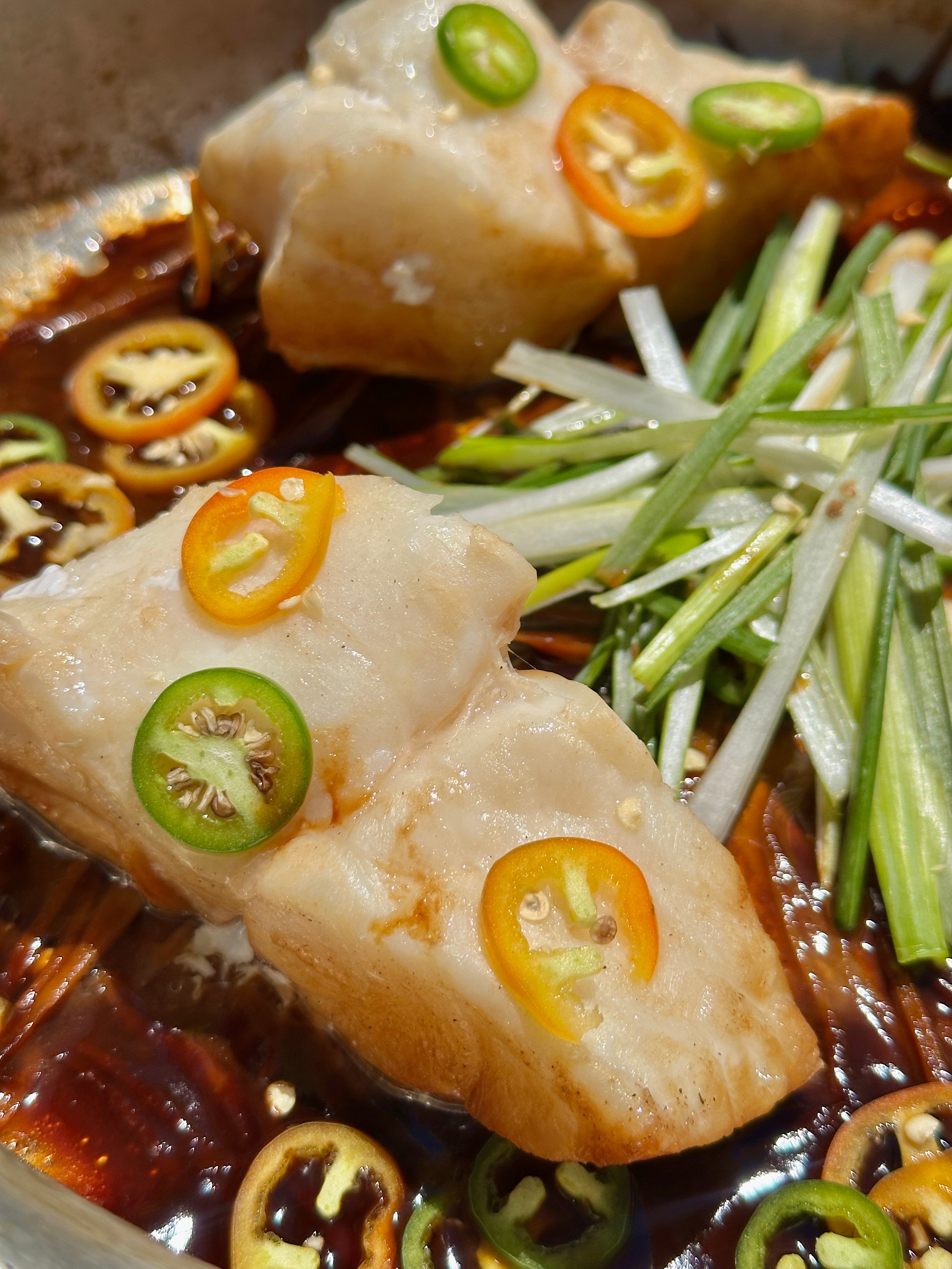 steamed yelloweye rockfish on a bed of chilis and vegetables