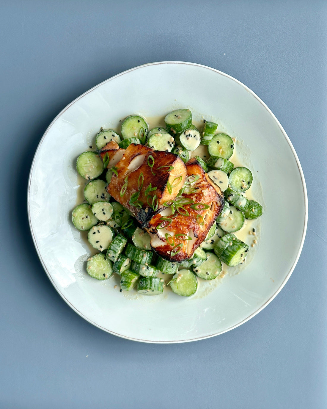 Plate with miso-glazed black cod and cucumbers